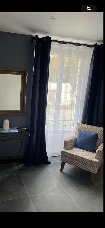 un salon avec une chaise et une fenêtre dans l'établissement Rambouillet, à Rambouillet