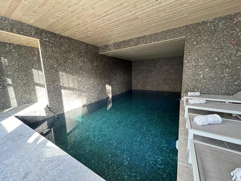 a swimming pool with blue water in a building at Hotel Heritage in De Haan