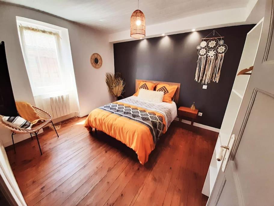 - une chambre avec un lit et un mur noir dans l'établissement Les fontaines, à Saint-Vincent