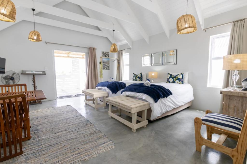 a bedroom with a bed with blue pillows at At3Brides Self Catering in St. Helena Bay