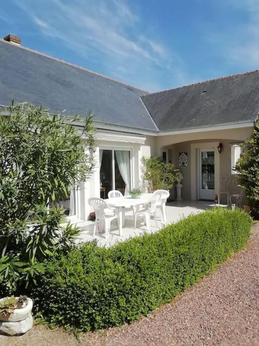 un patio avec une table et des chaises devant une maison dans l'établissement La Desirade, à Le Coudray-Macouard