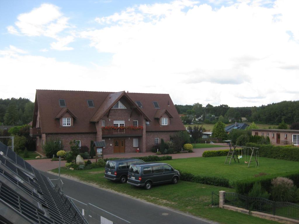 a house with two vehicles parked in front of it at Haus Schwielochsee in Schwielochsee