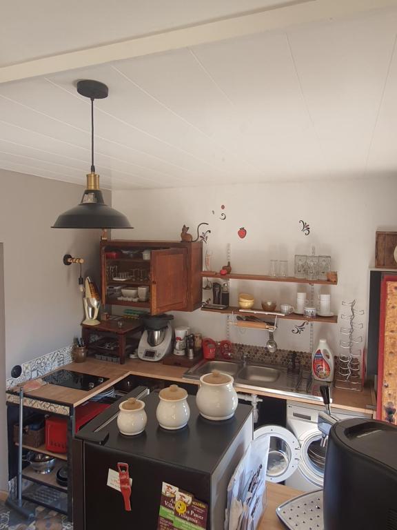 - une cuisine avec comptoir et vaisselle dans l'établissement La maison dô, à Frayssinet-le-Gélat
