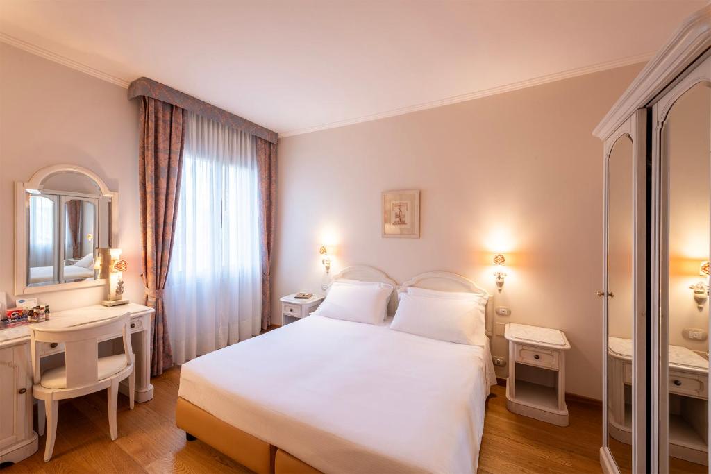 Postel nebo postele na pokoji v ubytování Majestic Toscanelli (centro storico)