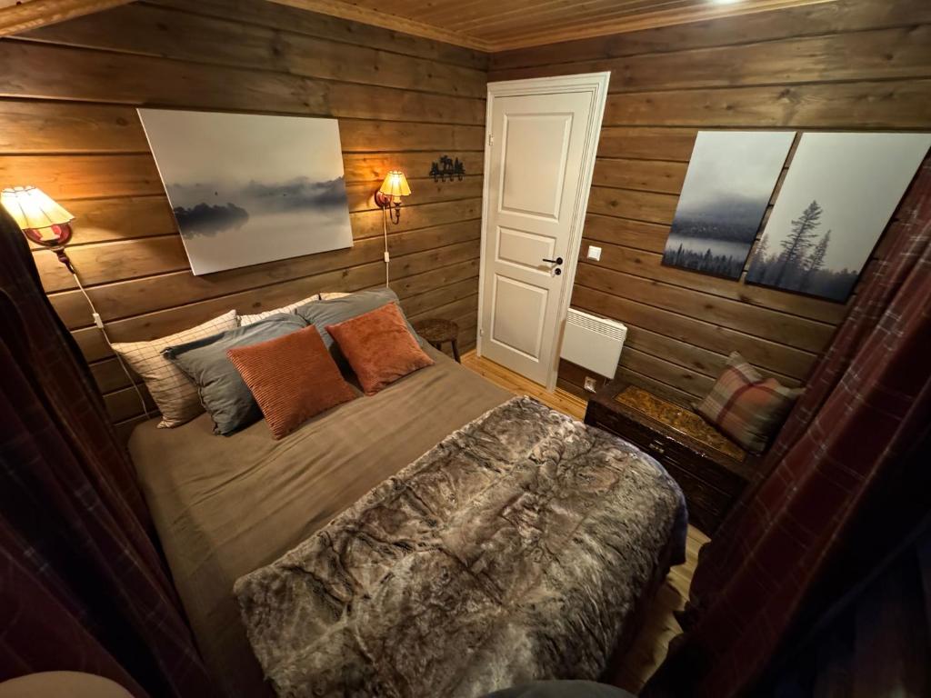 a bedroom with a bed and two pictures on the wall at Cottage Lavkavann Finnmarksvidda in Skoganvarre