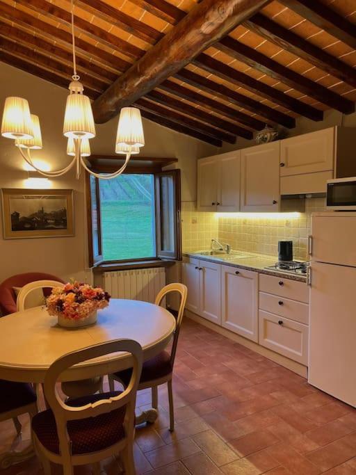 a kitchen with a table and some chairs and a table and a kitchen with at Antica Vigna Toscana in Poppi