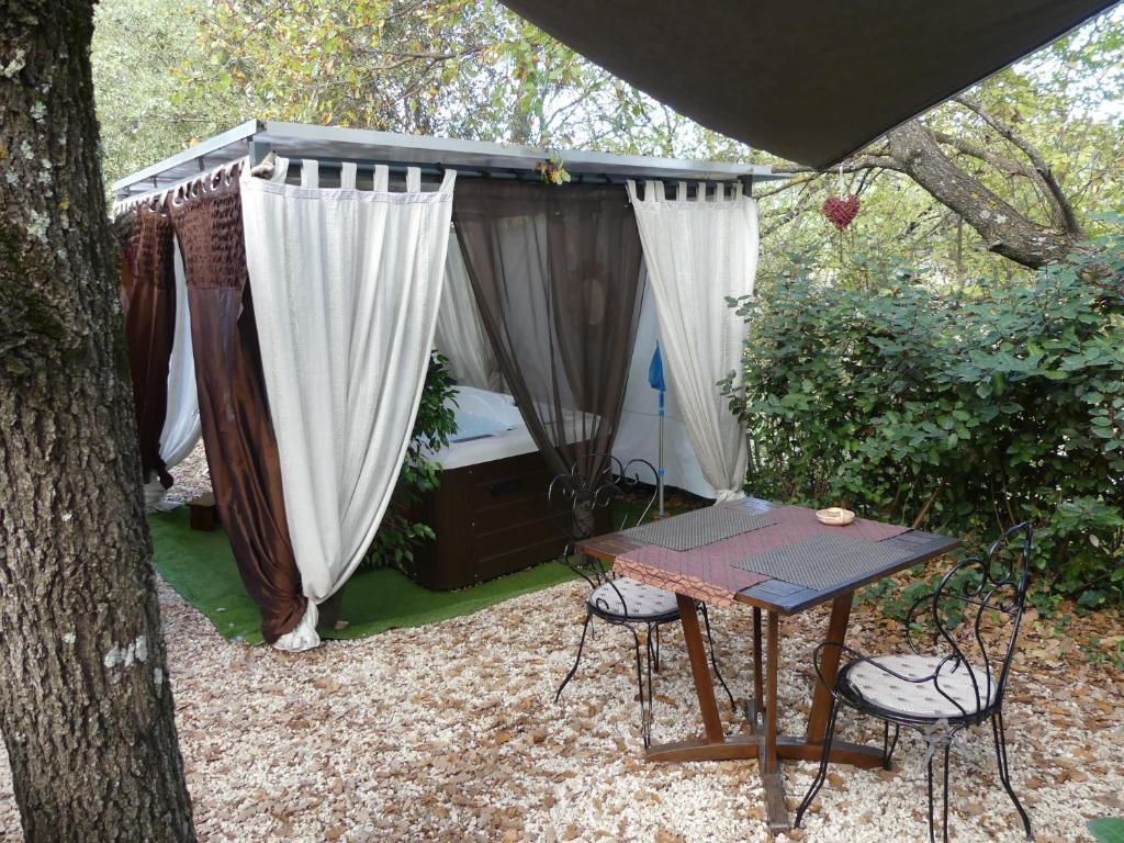 VaragesAu Cabanon Chez Nath - chbre d'hôtes的树下带桌椅的帐篷