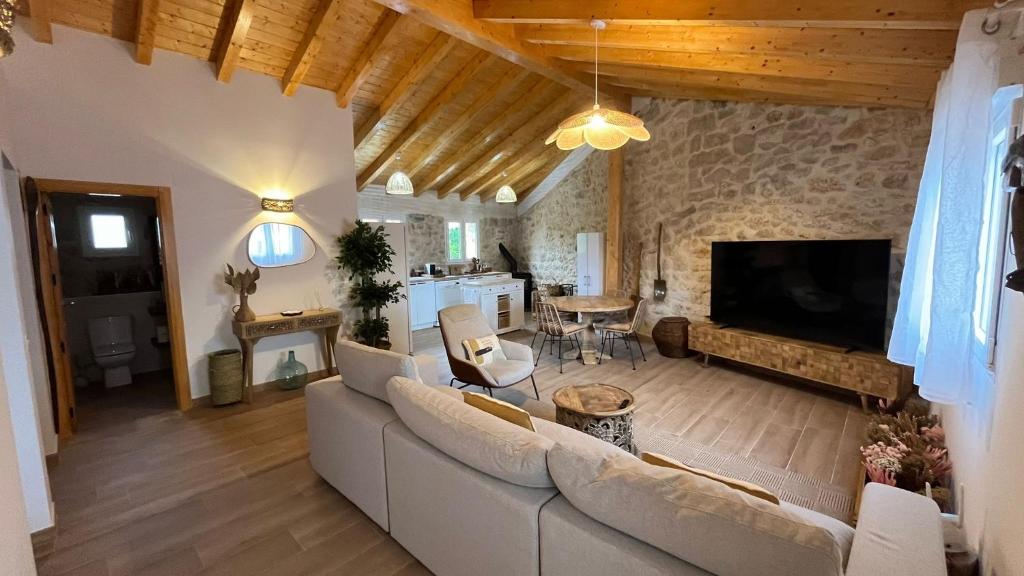 a living room with a white couch and a tv at Exclusive Ribera del Duero - TV 75 pulgadas, Netflix gratis y Wifi in Santa María de Mercadillo