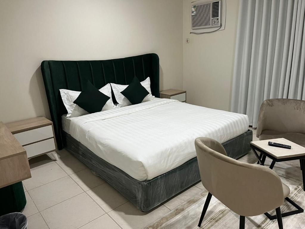 a bedroom with a large bed and a chair at وحدات سكنية مفروشة in Jeddah