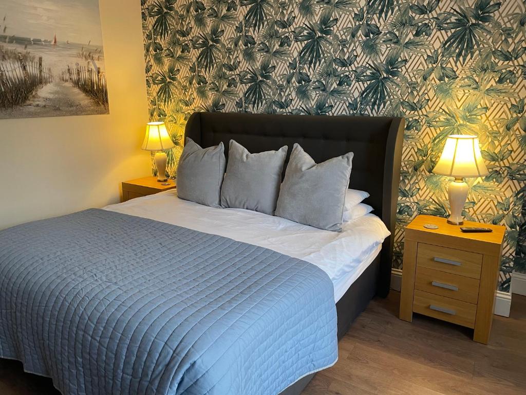 ein Schlafzimmer mit einem Bett und zwei Nachttischen mit Lampen in der Unterkunft Roker Cottage, luxury seaside apartment, private parking, sky tv in Sunderland