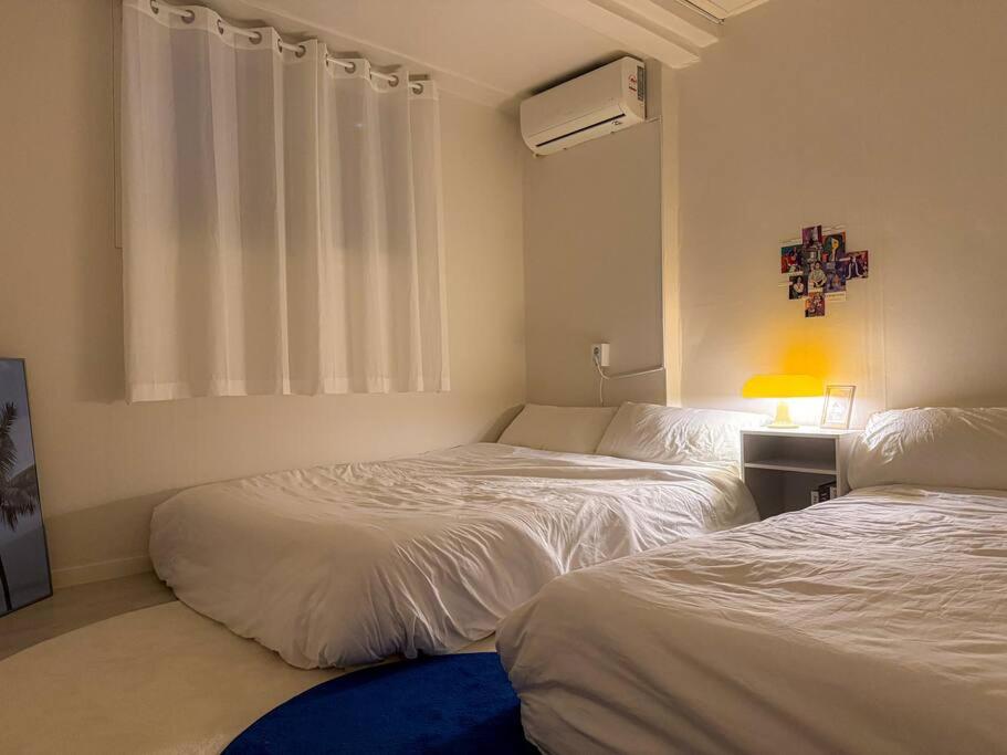 a bedroom with two beds and a window in it at Casa Choi 3 Bedroom Apartment in Seoul in Seoul