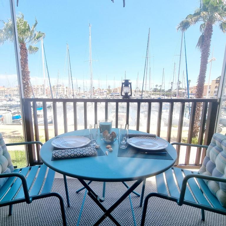 une table sur un balcon avec vue sur un port dans l'établissement L'escale du capitaine, à Leucate
