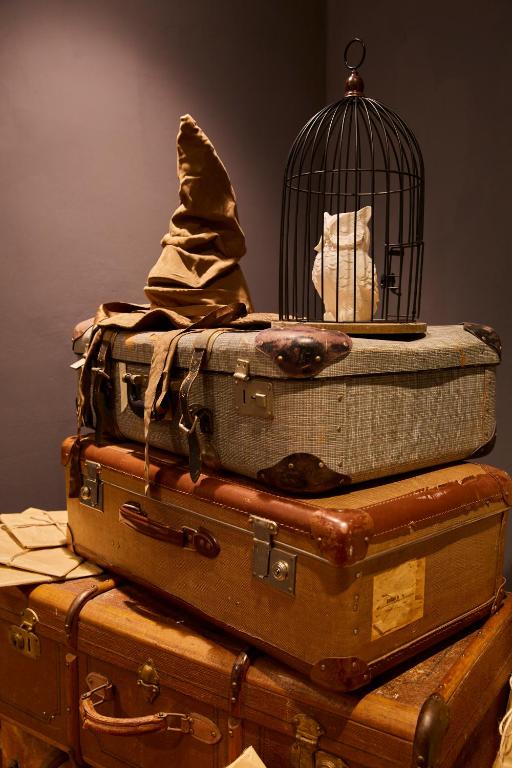 a stack of luggage with a bird cage on top at Wizard Apartment Hamburg - 3 Schlafzimmer - 156 qm mit Dachterrasse - bis 10 Personen - Dusche & Badewanne - Küche - Smart TV - kostenloser Parkplatz in Hamburg