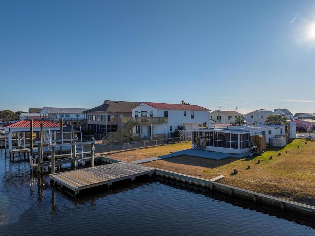 a dock on the water in front of some houses at Waterfront - Private Dock and Boat Lift on Canal - Pets Allowed in Surf City