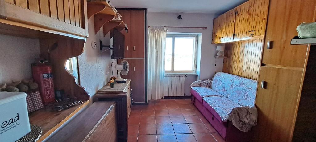 salon z kanapą i oknem w obiekcie Paradiso Aremogna w mieście Roccaraso