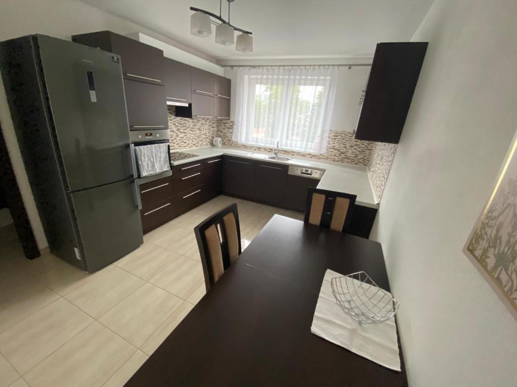a kitchen with a dining table and a refrigerator at Apartmán Hollého in Žilina