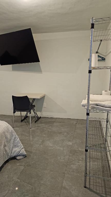 a room with a tv and a bed and a chair at Casa Cachi in Mexico City