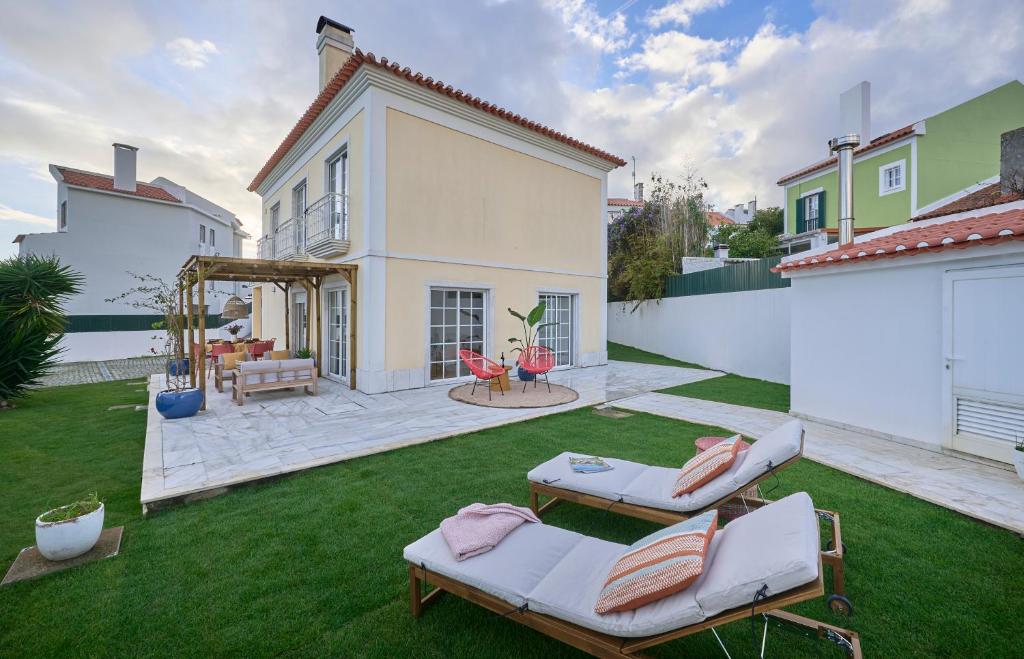 a yard with two lounge chairs and a house at Beach & Cascais Luxury Villa, By TimeCooler in Alcabideche
