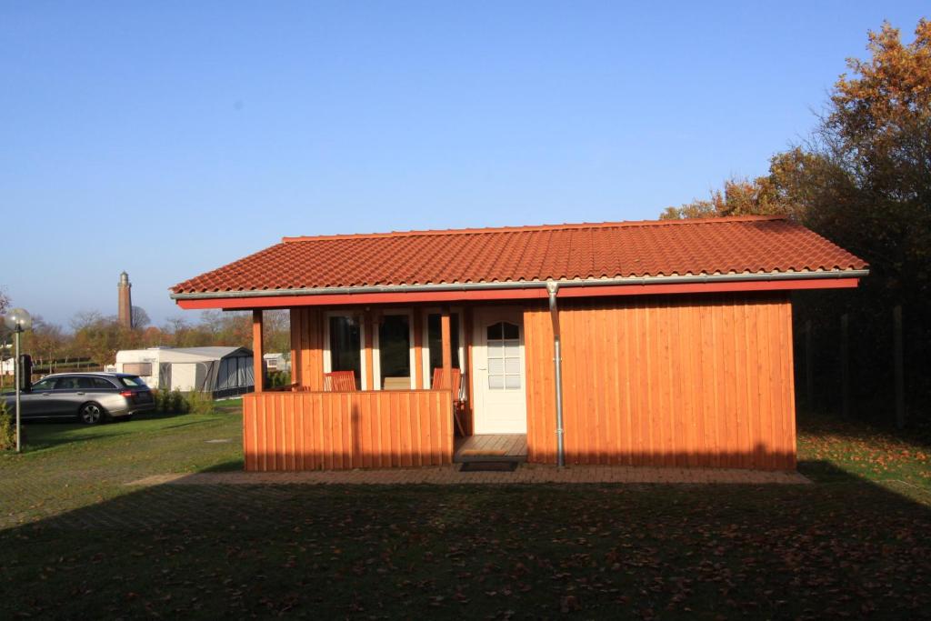 a small orange house with a red roof at Ferienhaus Campingpark Waldesruh in Behrensdorf