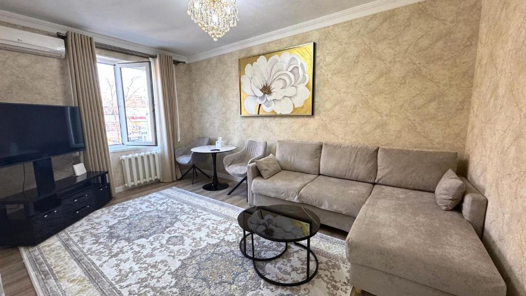 un salon avec un canapé et une télévision dans l'établissement Abay street- Tashkent city center, à Tachkent
