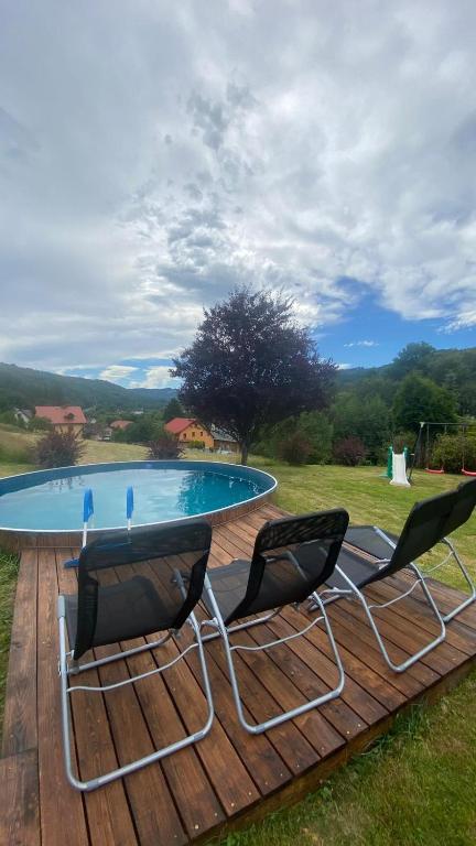 a table and two chairs on a deck next to a pool at Agroturystyka pod Baranią Gorą in Kamesznica