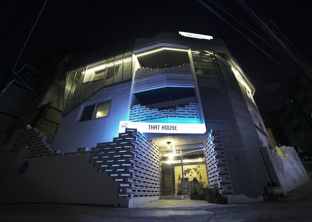 un grand bâtiment avec un panneau indiquant cette maison dans l'établissement That House Hongdae, à Séoul