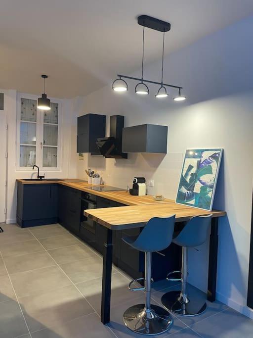 - une cuisine avec une table en bois et deux tabourets de bar bleus dans l'établissement Maison Hyper Centre - 200 M GARE, à Tours