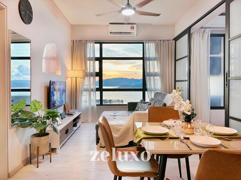 a living room with a table and a dining room with a view at Zeluxo #JQ02 Jesselton Quay Tower 2 Level 10-2 BR 1 Bath, Seaview in Kota Kinabalu