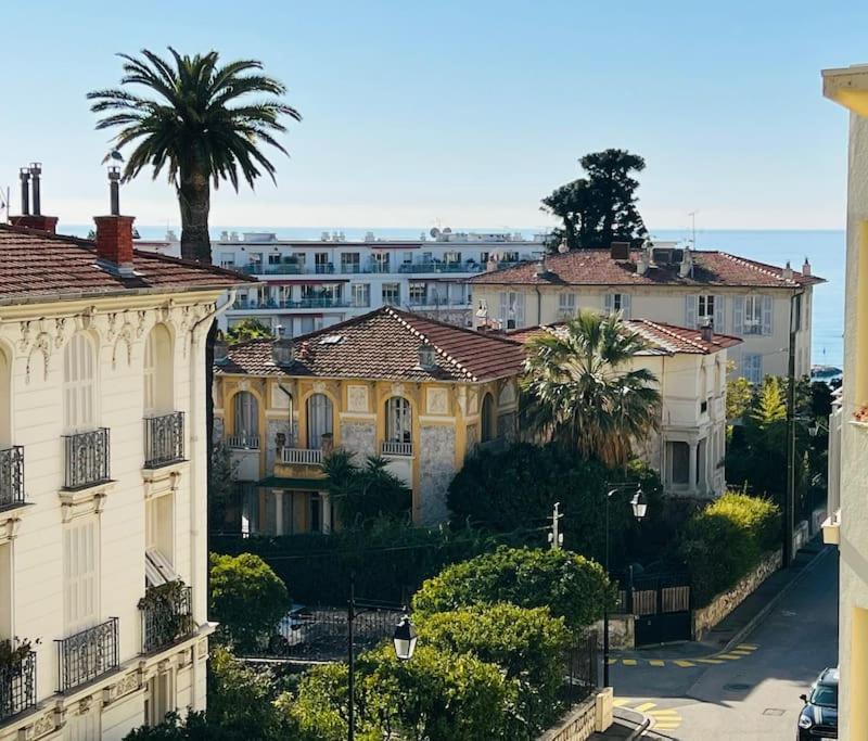 un groupe de bâtiments avec des palmiers et une rue dans l'établissement A 4 minutes de la plage dans le meilleur quartier, à Nice