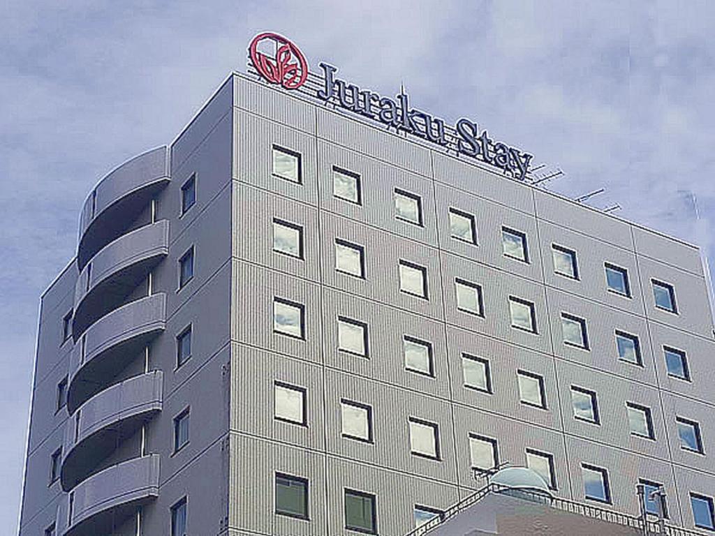 a building with a sign on the top of it at Juraku Stay Niigata in Niigata