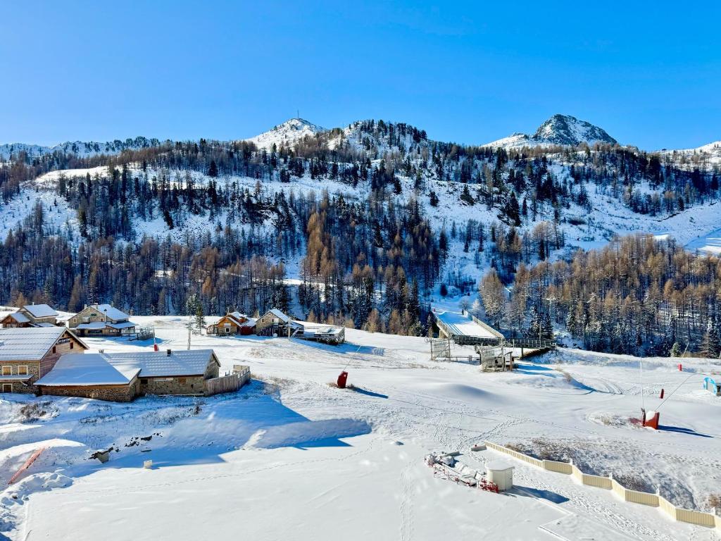 una montaña cubierta de nieve con casas y montañas en el fondo en 2 Pièces ISOLA 2000 - FRONT DE NEIGE, en Isola 2000