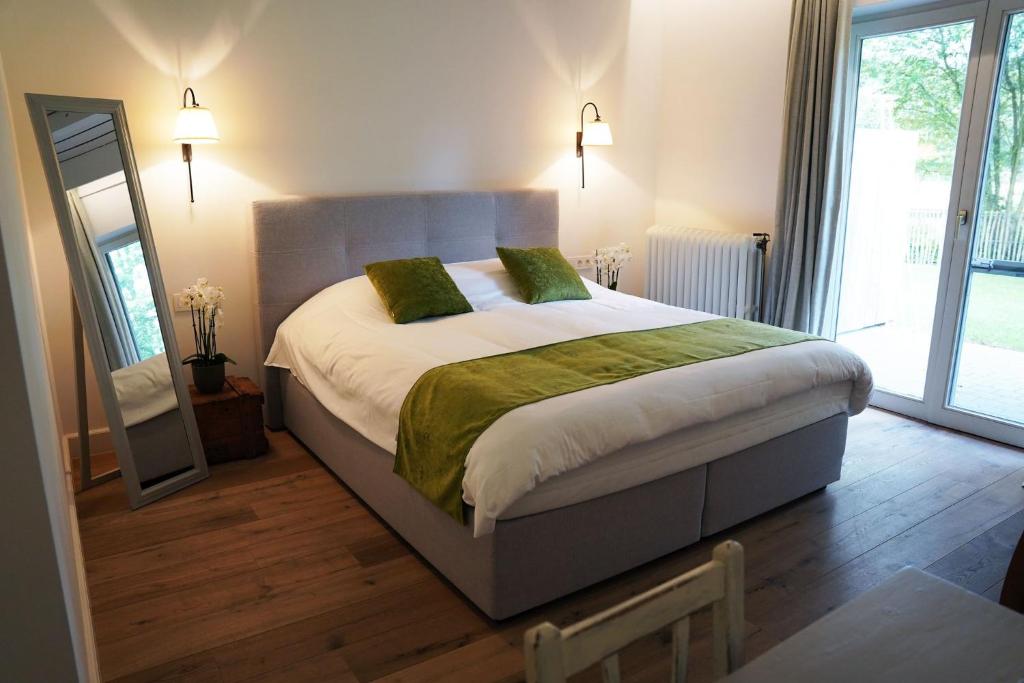 TessenderloにあるBoutique hotel-restaurant De Lindehoeveの大きなベッドと鏡のある寝室