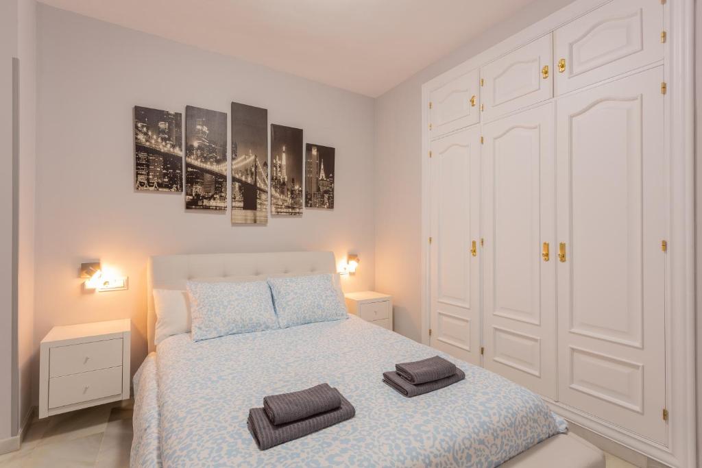 Hotel Centro de Granada, cerca de la Catedral, a white bedroom with a bed with two towels on it at Centro de Granada, cerca de la Catedral in Granada