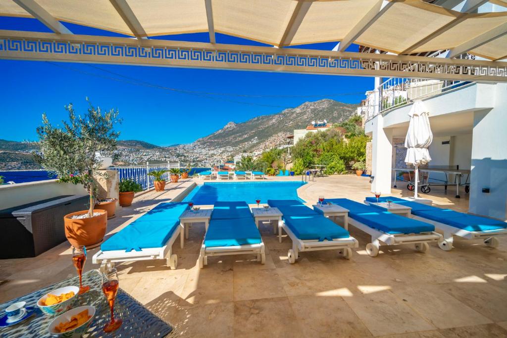 una piscina con tumbonas azules y una piscina en ViLLA SİRİ, en Kas