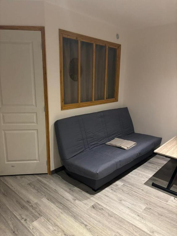 un letto blu in una stanza accanto a una porta di Appartement meublé T1 Lussac les Chateaux a Lussac-les-Châteaux