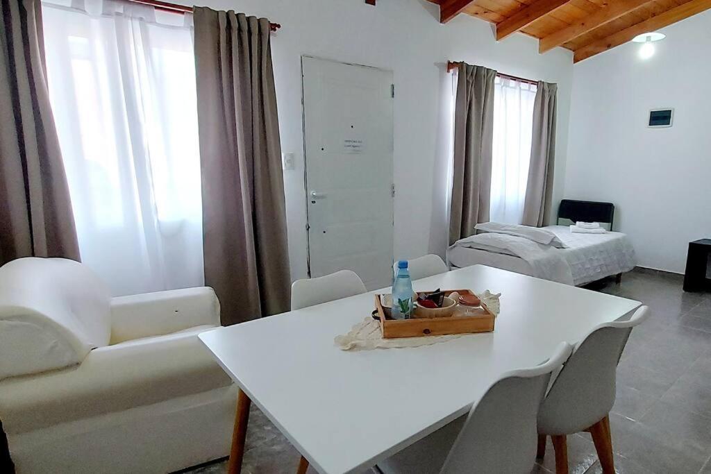 ein Wohnzimmer mit einem weißen Tisch und einer Couch in der Unterkunft La Fueguina Departamento 4 en Gobernador Gregores in Gobernador Gregores