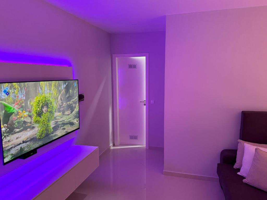 a purple living room with a fish tank on a wall at Alojamento Ribeirinha in Mindelo