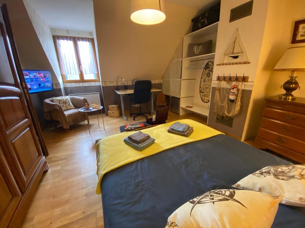 a bedroom with a bed and a living room at Gite au Charme de la Forêt avec jardin Accès à pied Circuit des 25 Bosses in Le Vaudoué