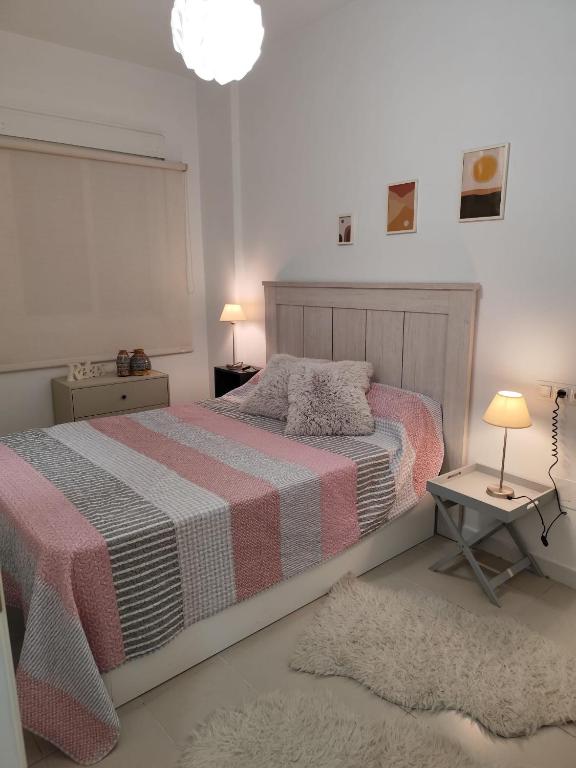 a bedroom with a bed and a table with a rug at San Nicolas Apartaments in Fuengirola