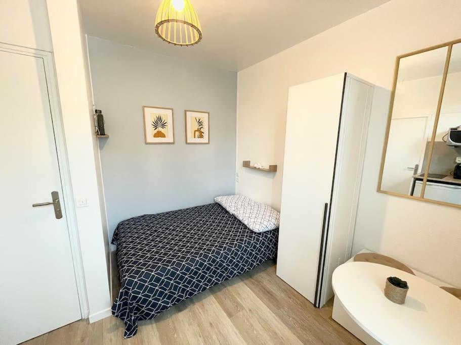- une petite chambre avec un lit et un réfrigérateur dans l'établissement Studio cosy 10min de Paris & CDG, à Drancy
