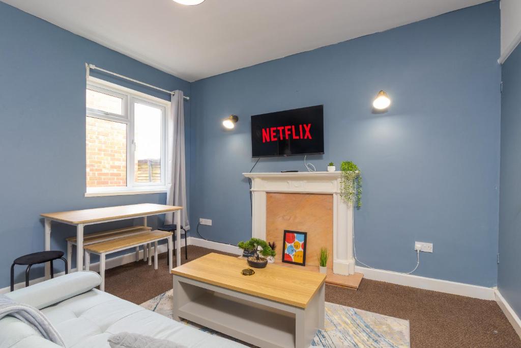 a living room with a tv above a fireplace at HIGH STREET APARTMENT, SLEEPS 6 GUESTs! in Bedworth