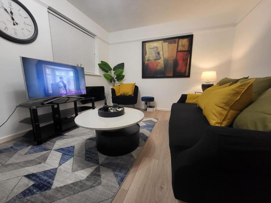 a living room with a couch and a table and a tv at Cosy 2 Bedroom Apartment in Stifford