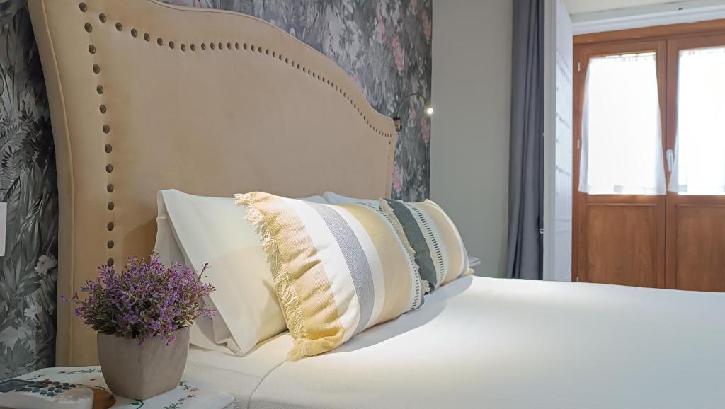 a white bed with a bunch of pillows on it at Sherryflat Catedral in Jerez de la Frontera