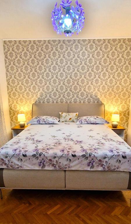 a bedroom with a bed with a purple comforter at Apartments Elena Green Island Escape in Ugljan