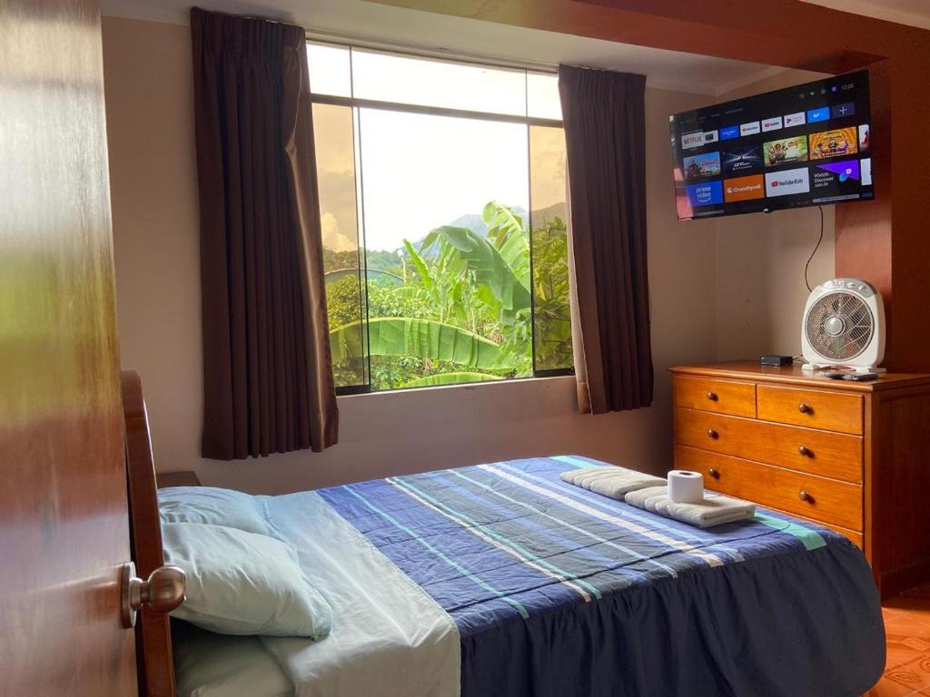 una camera con un letto, una finestra e una TV di Casa Hospedaje Inkani a La Merced