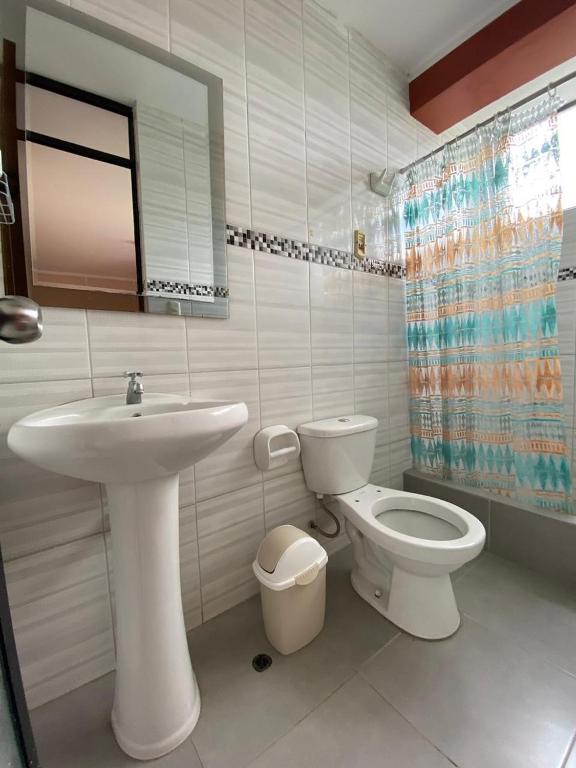 un bagno bianco con lavandino e WC di Casa Hospedaje Inkani a La Merced