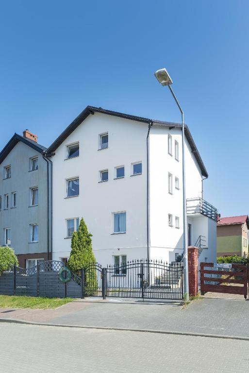 a white building with a street light in front of it at SŁONECZNIK in Ostrowo