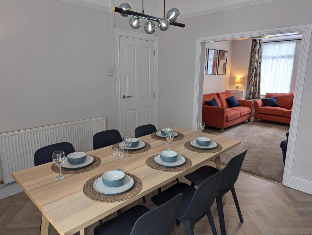 Un comedor con mesa y sillas de madera. en Spacious Family Holiday Home, en Porthcawl