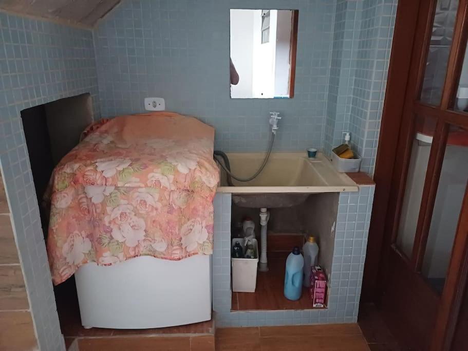 a small bathroom with a bed and a sink at Seu descanso merecido está aqui in São Sebastião