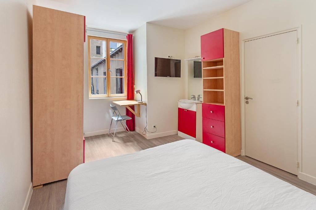 Un dormitorio pequeño con una cama y un escritorio. en Chambres centre-ville avec espaces partagés - accessibles et abordables, en Nantes